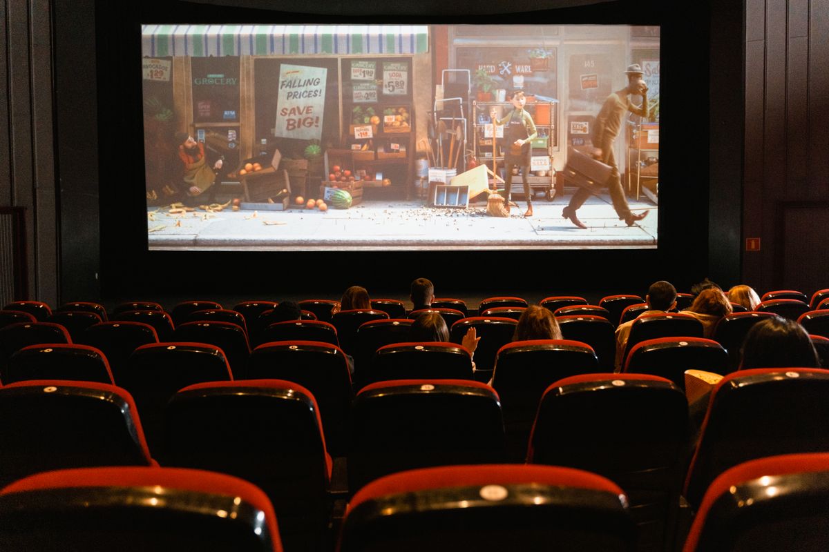 Audience watching a large screen in a darkened theatre — bilingual viewing on meWATCH