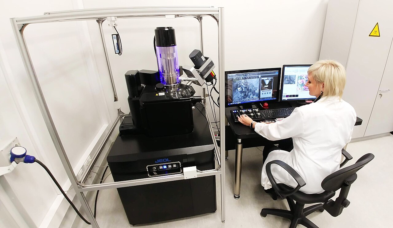 Forensic scientist operating an electron microscope in a laboratory